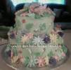 light green baby cake with pastel flowers and bugs