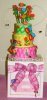 colorful pink yellow and green cake with bright flowers and bugs