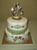 white cake with green bow and purple flowers