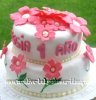 white baby shower cake with bright pink flowers