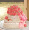 white a pink polka dot cake with pink roses and a bow