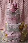 girl diaper cake wrapped with pink and white receiving blankets with silver mesh ribbon