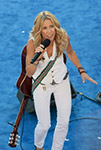 sheryl crow singing on stage with guitar