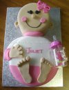 baby shaped cake with pink and white outfit