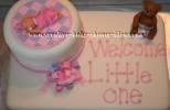 white teddy bear baby shower cake that says welcome little one