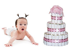 surprised diaper on tummy next to pretty diaper cake