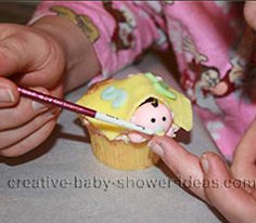 painting the baby pacifier for the shower cupcakes