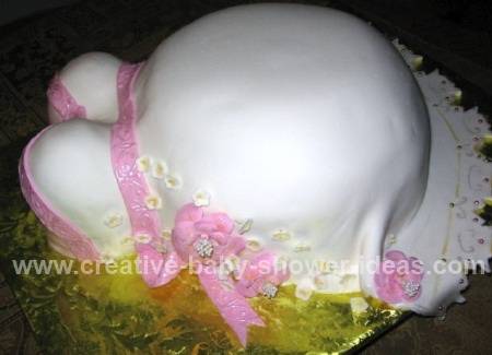 side view of pink and white pregnant belly cake