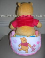 back of blanket winnie the pooh diaper cake showing baby bib